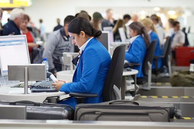 Foto de luchthavenmedewerker registreert de bagage checkin op de luchthaven