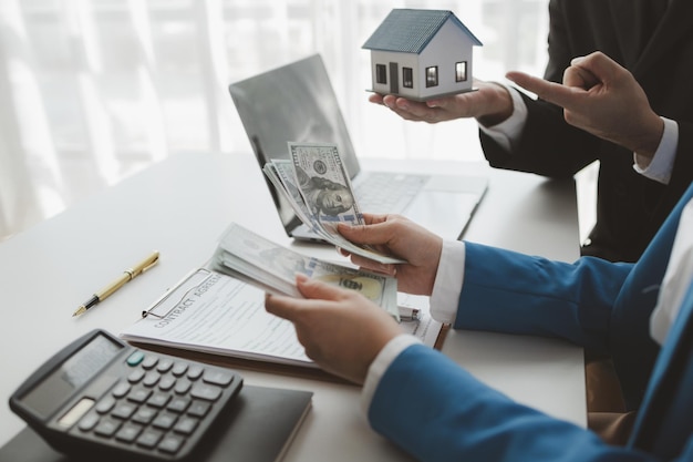 De makelaar ontvangt de eerste termijn van de aankoop van de woning van de koper Het tellen van de termijnbetalingen van de klanten Maak een afspraak om de klant te ontmoeten bij het kantoor voor de verkoop van woningen