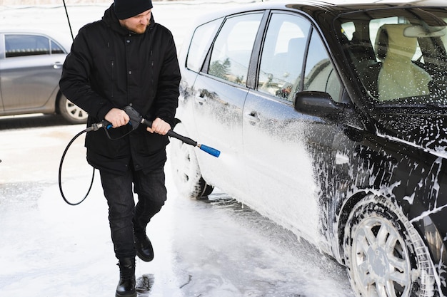 De man die zijn auto wast op selfservice carwash express carwash