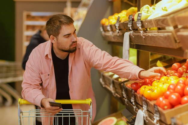 De man doet aankopen in de supermarkt het concept van winkelen