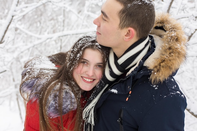 De man en het meisje rusten uit in het winterbos Man en vrouw in de sneeuw Jong stel