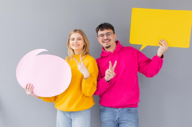 De man en vrouw houden een dialoogtekens op de grijze achtergrond