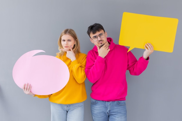 De man en vrouw houden een dialoogtekens op de grijze achtergrond