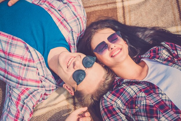 De man en vrouw met zonnebril lagen op de grond