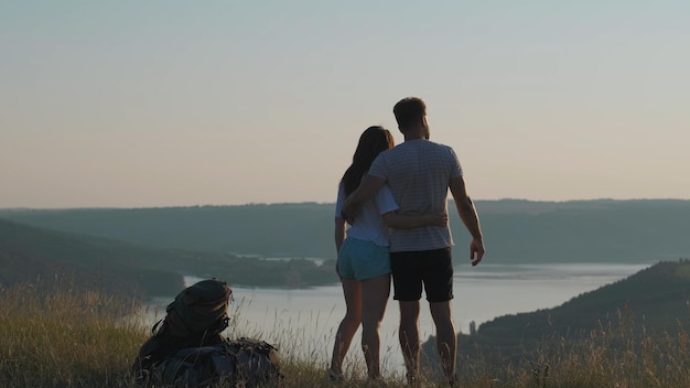 De man en vrouw staan op de bergtop boven de prachtige rivier