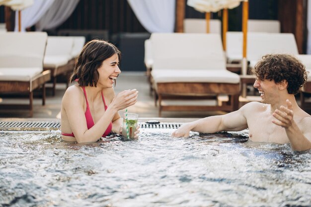 De man flirt met een meisje in de jacuzzi Paar ontspannen in het zwembad en genieten van de zomer