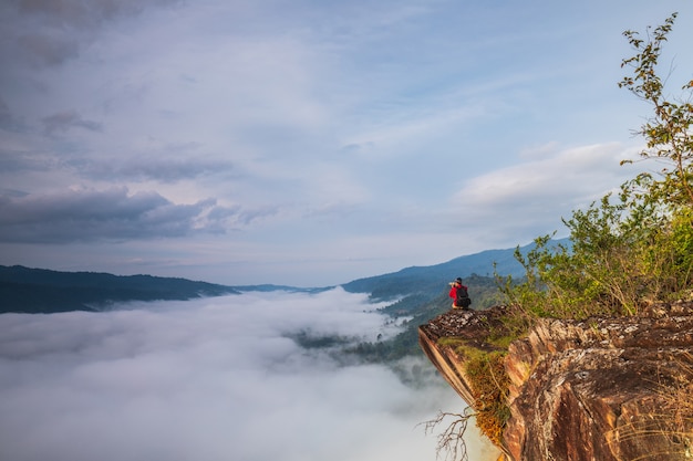 De man fotografeert de zee van mist op de hoge berg.