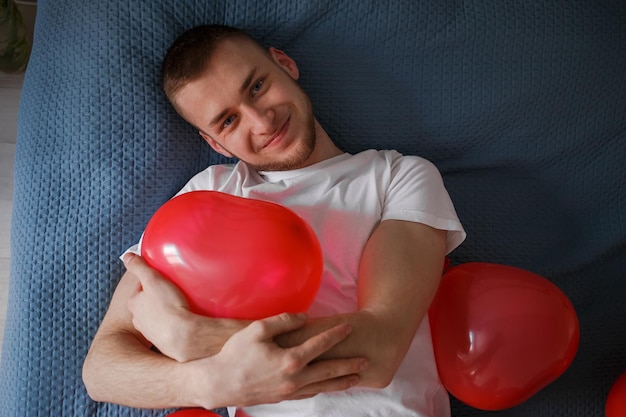 De man houdt een ballon vast in de vorm van een hart voor Valentijnsdag