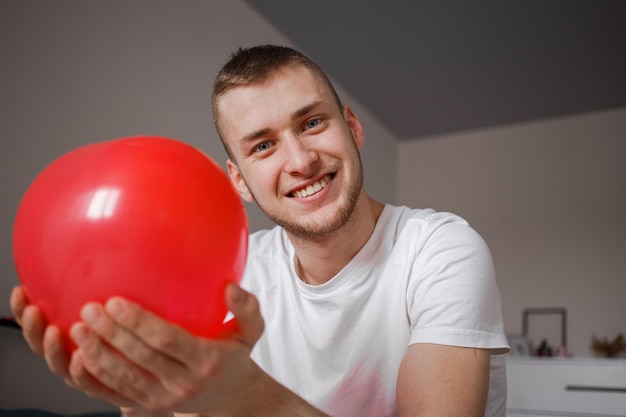 De man houdt een ballon vast in de vorm van een hart voor Valentijnsdag