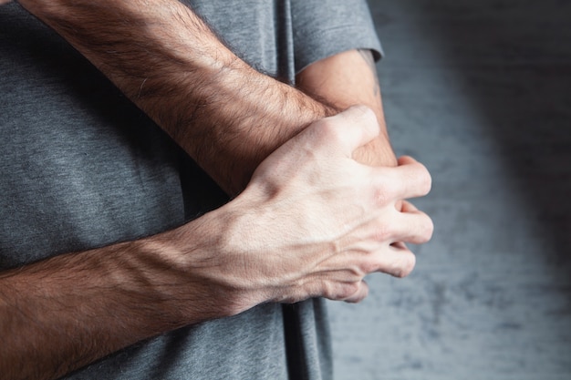 De man houdt elkaars hand vast. Elleboog pijn