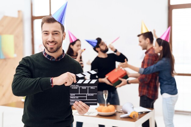 De man in de dop houdt de film clapperboard.