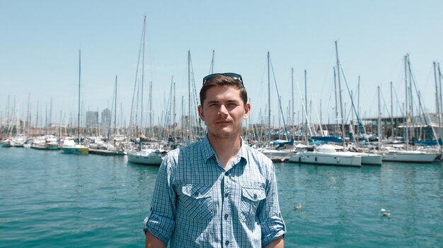 Foto de man in het blauwe shirt op de achtergrond van het jacht