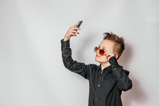 De man in het zwarte shirt maakt een selfie aan de telefoon