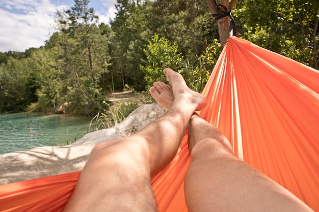 De man is aan het chillen en relaxen in de hangmat in het kamp