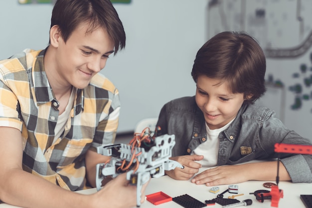 De man laat de jongen zien hoe de robot is gerangschikt