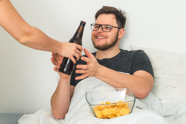 De man lag in het bed en gaf hem een biertje