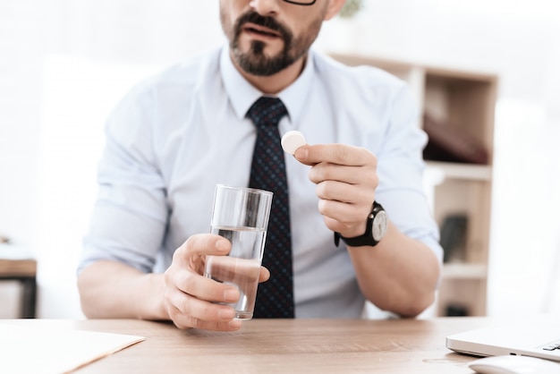 De man maakt zich klaar om medicijnen te drinken.