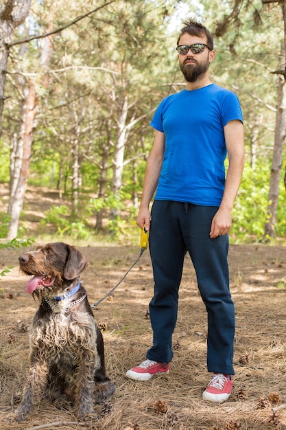 De man met de hond in het park Duitse jachtwaakhond drahthaar