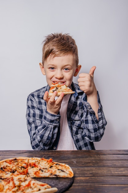 Foto de man met veel plezier eet een stuk pizza en toont zoals op een witte achtergrond