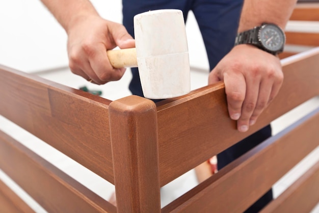 De man monteert houten meubels in huis