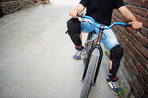 De man op de fiets zit op de achtergrond van de muur van rode baksteen