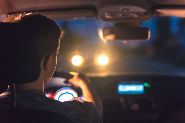 De man rijdt in een auto. avond nacht tijd