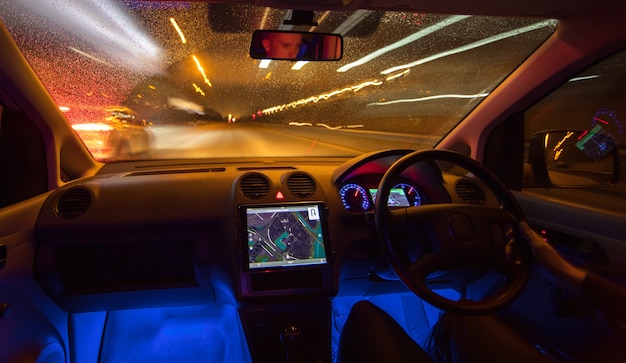 De man rijdt met een kaart op de weg. Avond nacht tijd. Links verkeer