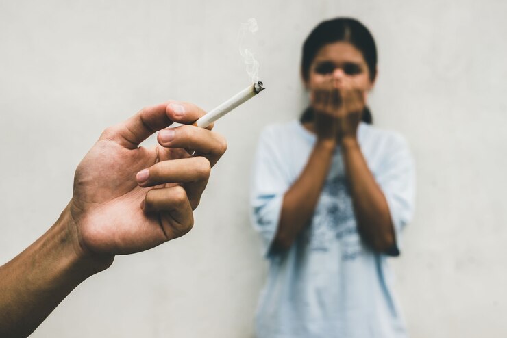 Foto de man rookt een sigaret en de vrouw bedekt haar gezicht. passief roken en gezondheidszorg of geen tabaksdagconcept.
