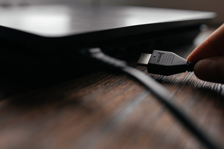 De man sluit de HDMI-kabel aan op het apparaat en steekt deze in de HDMI-poort