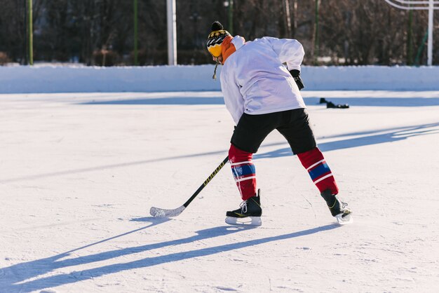 De man speelt hockey op de ijsbaan