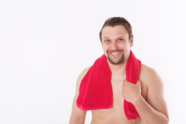 De man streelt zijn baard. ochtendbehandelingen in de badkamer. blauwe handdoek om haar nek. geïsoleerd op een witte achtergrond. kopieer ruimte