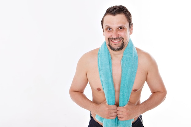 De man streelt zijn baard. ochtendbehandelingen in de badkamer. blauwe handdoek om haar nek. geïsoleerd op een witte achtergrond. kopieer ruimte