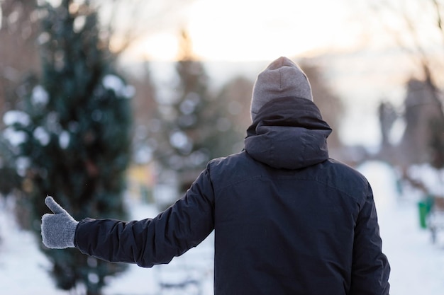 De man toont de klas in handschoenen Handen in grijze winterhandschoenen Palm met een handschoen in de sneeuw De man gooide sneeuw