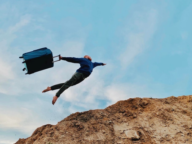 Foto de man vliegt met een koffer boven de grond.