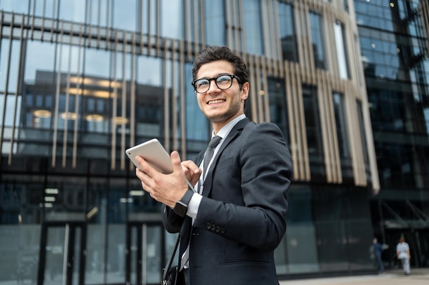 De manager gebruikt een tablet om een communicatiebericht te schrijven naar een collega een man met een bril