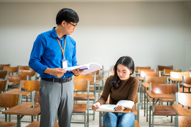 De mannelijke leraar onderwijst boeken in het universitaire klaslokaal