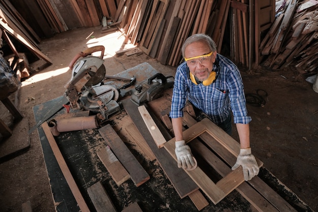 De mannelijke timmerman gebruikt schuurpapier om het houtwerk te polijsten.