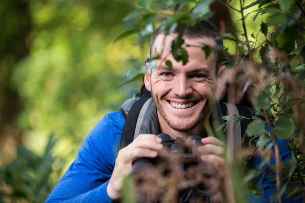 De mannelijke verrekijkers van de wandelaarholding in bos