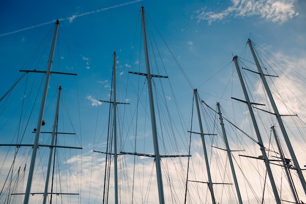 De masten van het zeejacht op de pier, verlicht door de zon