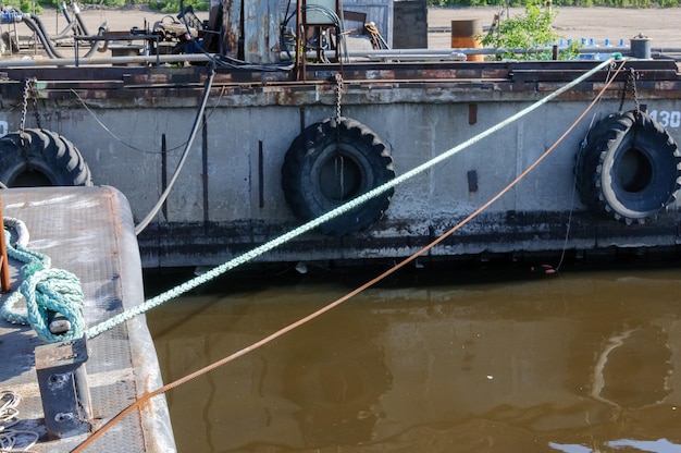 De meermuur in de haven hing met oude banden