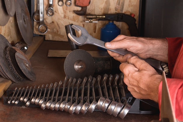 de meester-slotenmaker houdt een multifunctionele sleutel in handen de werkplek boven een set sleutels wrench