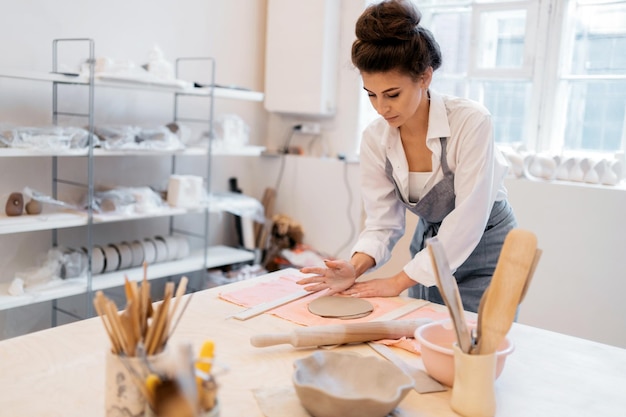 De meester van keramiek maakt een product De vrouw maakt graag handgemaakte kleiplaten