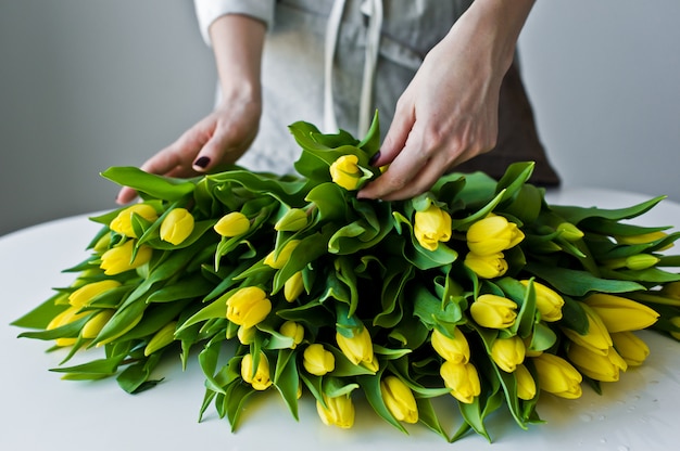 De meisjesbloemist zet op de lijst gele tulpen.