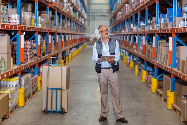 De mening van manager houdt een tablet en bekijkt planken