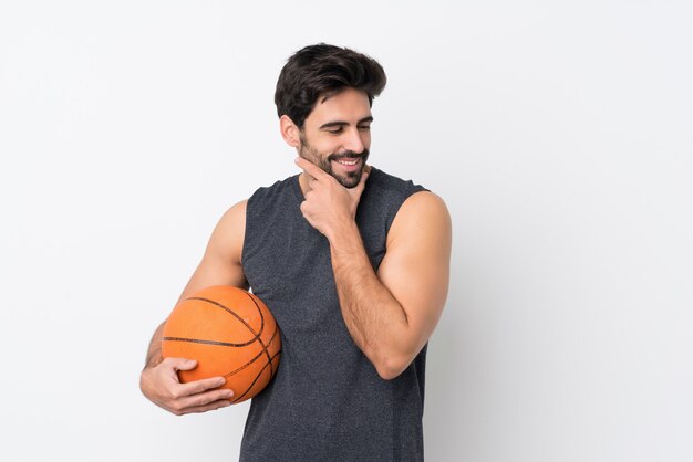 De mens die van de basketbalspeler met baard over geïsoleerde witte muur kant kijken