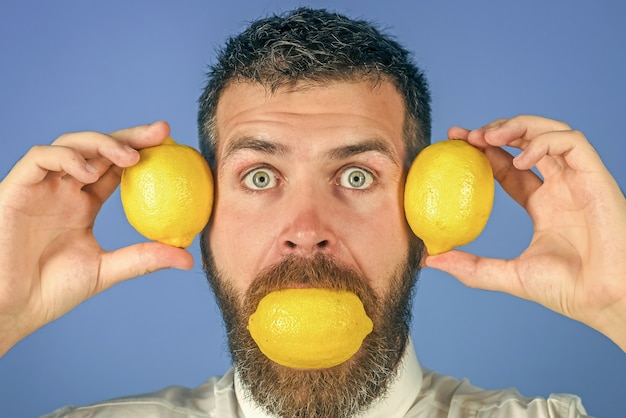 Foto de mens eet citroen fruit en gezonde biologische voeding fynny citrusvruchten