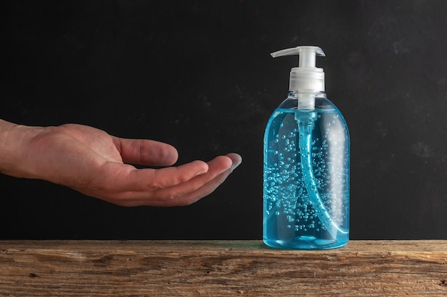 De mens gebruikt handdesinfecterende alcoholgel om handen te wassen.