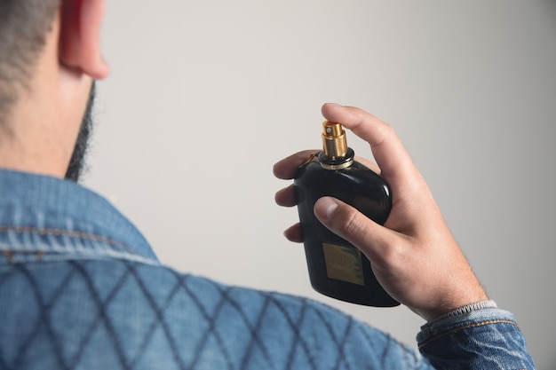 De mens gebruikt mannelijk parfum voor zichzelf