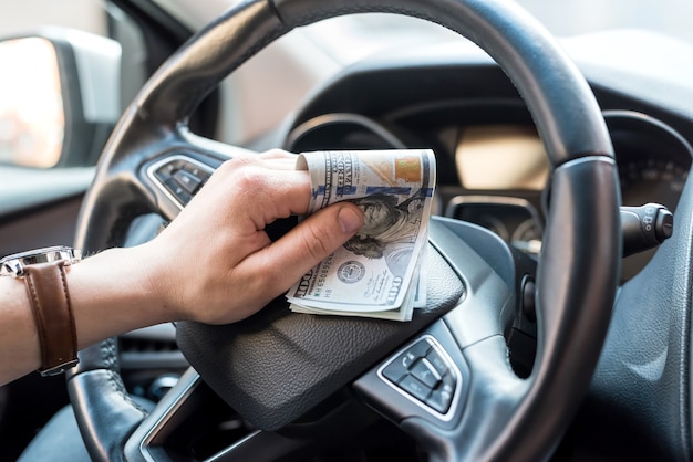 De mens in zijn auto telt ons geldrekeningen voor het concept van betalenfinanciën