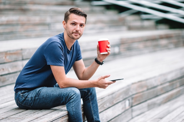 De mens leest tekstbericht op mobiele telefoon tijdens het wandelen in het park